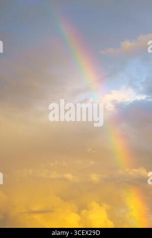Rainbow against cloudy sunset sky. Natural background. Weather after rain. Stock Photo