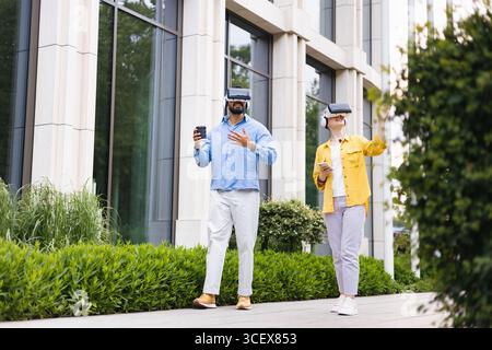 People Using VR Headsets Outdoors Stock Photo