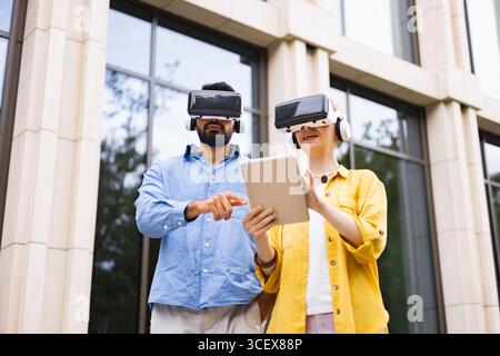 Couple Using VR Headsets Outdoors Stock Photo