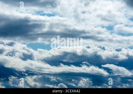 Layered Cumulus and Stratus Clouds in a Vivid Blue Sky – Natural Sky Texture. Stock Photo