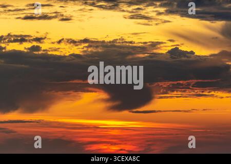 Dramatic Sunset Sky with Fiery Orange, Red, and Black Clouds – Evening Natural Atmosphere. Stock Photo