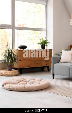 Glucophone with plant on commode near window in room Stock Photo
