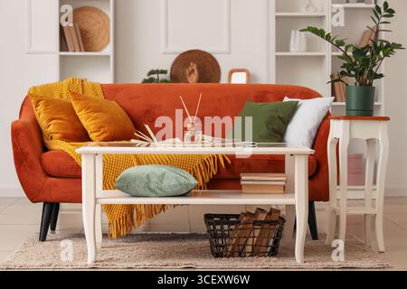 Coffee table with books, magazine and aroma sticks in stylish living room Stock Photo