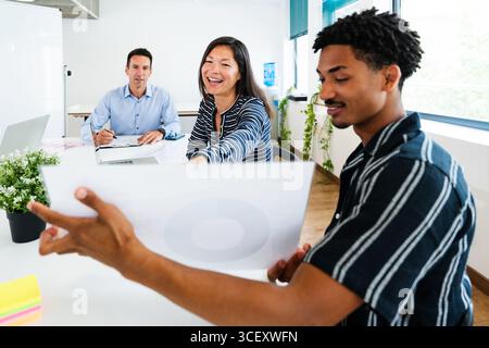 Business team members engaging in a collaborative discussion during a dynamic office meeting, exchanging ideas and working together on important proje Stock Photo