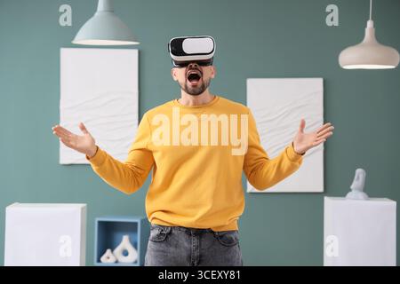 Shocked young man with VR glasses in art gallery Stock Photo