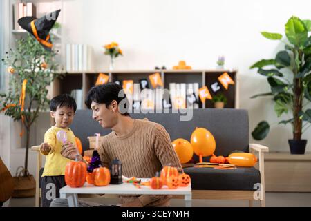 Halloween Celebration. Father and son enjoying festive pumpkin decorations together. Stock Photo