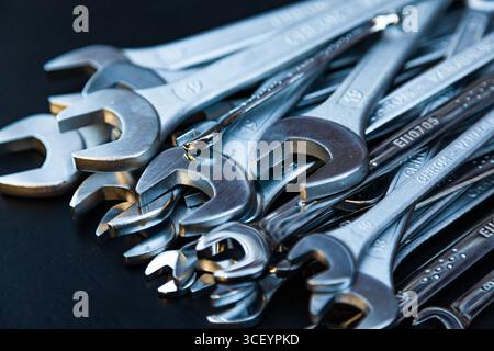 Pile of new wrenches on a black background, close-up. Stock Photo