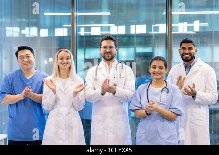 Healthcare professionals, including doctors and nurses, applauding together in a contemporary medical setting, representing teamwork, appreciation, and dedication in the medical field. Stock Photo