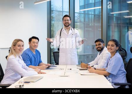 A group of diverse healthcare professionals engage in a collaborative discussion in a modern office, sharing ideas and collaborating on strategies for patient care and organizational improvement. Stock Photo
