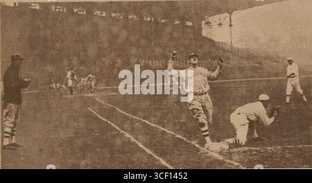 On November 12, 1924, a moment during a baseball game between the Giants and the White Sox is captured, showing a runner reaching base at the same time the opposing player catches the ball. This is a dramatic moment during a key play. Stock Photo