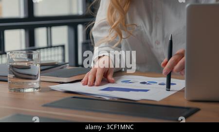 Close up Caucasian business woman anxiety with bad documents result failure upset holding head analyzing financial data working at office table desk Stock Photo