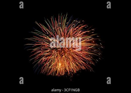 Multiple fireworks bursts captured against a dark sky Stock Photo