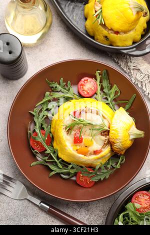 Tasty stuffed pattypan squash with tomatoes and arugula served on grey table, flat lay Stock Photo