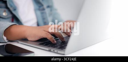Person hands typing on a laptop keyboard, representing a professional or student working, coding, or studying. The clean and bright setting is ideal f Stock Photo