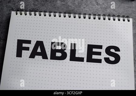 Concept of Fables write on book isolated on Wooden Table. Stock Photo