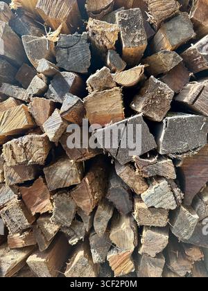Stack of chopped firewood prepared for storage or use in a fireplace or wood-burning stove. Stock Photo
