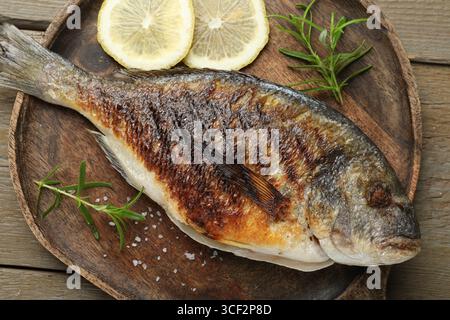 Tasty roasted dorado fish and spices on wooden table, top view. Homemade seafood dish Stock Photo