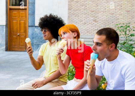 Three friends enjoying ice cream cones outdoors Stock Photo