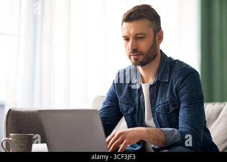 Middle-aged businessman working from home, using laptop Stock Photo