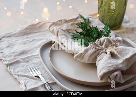 Plate setting with natural linen napkins decorated for Christmas dinner Stock Photo