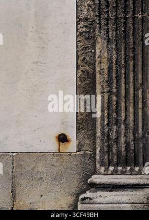 A column relief on a wall, rusty screw, stones, marble, stucco Stock Photo