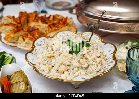 A delightful spread featuring a traditional olivier salad, surrounded by various appetizers and dishes. perfect for festive gatherings and celebration Stock Photo