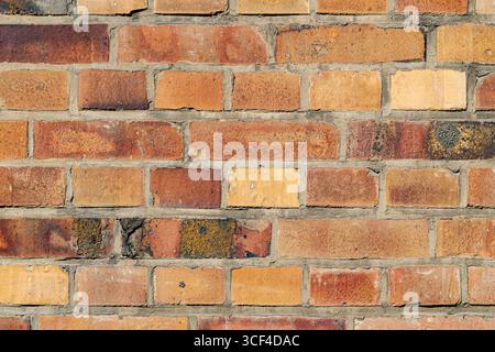 Bright, colorful bricks in warm tones ranging from orange to yellow, sunlit and lively. Stock Photo