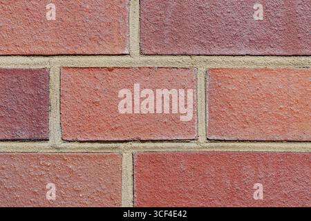 A detailed closeup of a modern red brick wall with clean, sand-colored mortar lines. Stock Photo