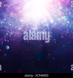 Sparkling glitter dust creating a mystical vibrant pink, purple, and blue bokeh of lights. Dreamy or magical shimmering particles softly glowing. Ethe Stock Photo
