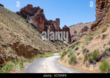 Leslie Gulch Road winds through the basalt spires that rise from the caldera floor at the Leslie Gulch Area of Critical Environmental Concern in Orego Stock Photo
