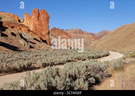 Leslie Gulch Road winds through the basalt spires that rise from the caldera floor at the Leslie Gulch Area of Critical Environmental Concern in Orego Stock Photo