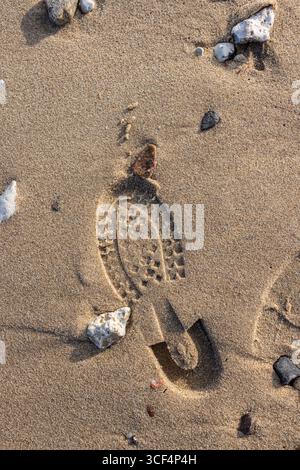 Shoe sole prints in the sandy soil, background image Stock Photo