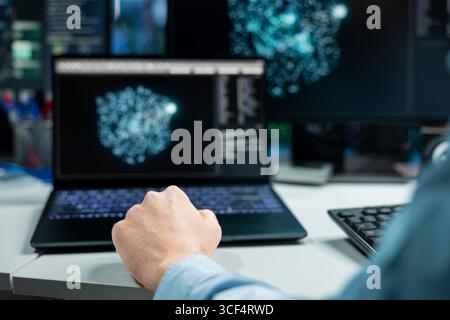 Close up of data center developer using laptop, monitoring AI systems, adjusting machine learning parameters. Server room IT professional using notebook, enhancing artificial intelligence performance Stock Photo