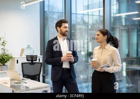 Professionals interacting in an office space, showcasing a collaborative work environment and professionalism. Stock Photo