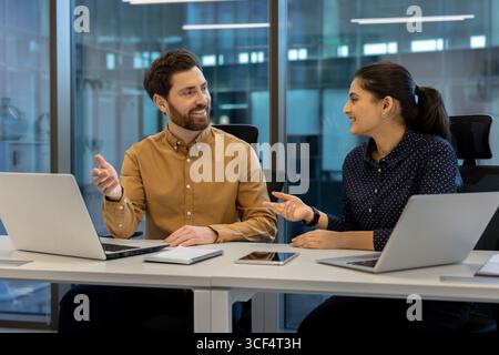 Professional collaboration between two coworkers in a modern workspace setting. Stock Photo