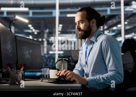 Software developer in data center using AI powered tech to run simulations. IT specialist coding cognitive computing algorithms to extract insights from data and automate infrastructure Stock Photo