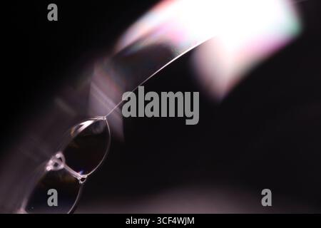 Abstract macro of sharp light refractions and iridescent soap bubbles with geometric prism effects on a dark background Stock Photo