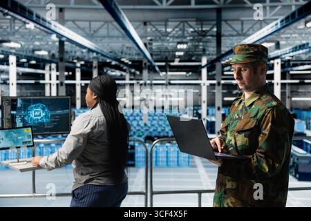 Team of army tech experts in data center conducting threat simulations using AI neural networks. Teamworking server farm colleagues using artificial intelligence supporting military operations Stock Photo