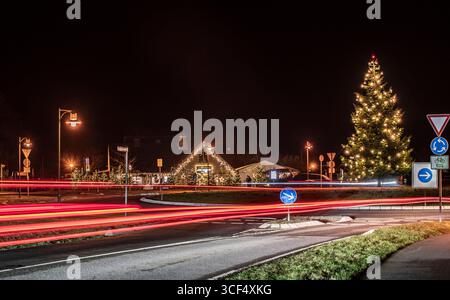 Light trails on the traffic circle with Christmas decorations Stock Photo