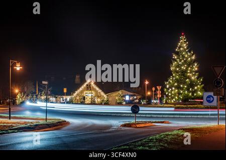 Light trails on the traffic circle with Christmas decorations Stock Photo