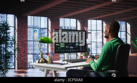 African american engineer at home working on visual coding on terminal window, typing programming language and reviewing the notes tree. IT expert using debugging algorithms to fix errors. Camera B. Stock Photo