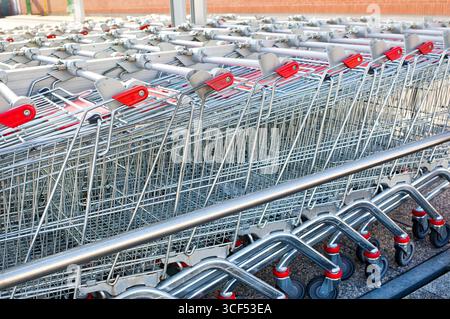Rows of shopping carts at the entrance of supermarket Stock Photo