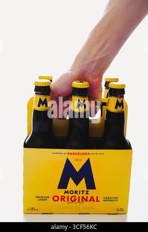 Closeup of a young man carrying a six-pack cardboard carrier case against a white background Stock Photo