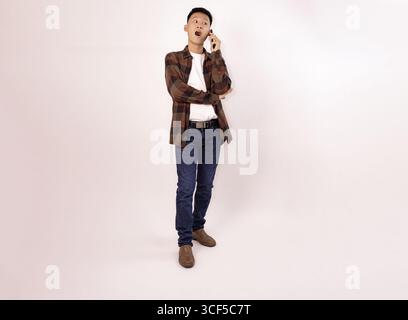 casual young man talking on mobile phone in relaxed pose Stock Photo