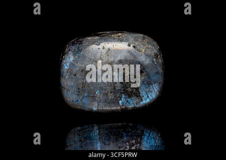 Closeup polished larvikite stone (blue pearl granite, black labradorite) a variety of an igneous rock (monzonite) on dark background Stock Photo