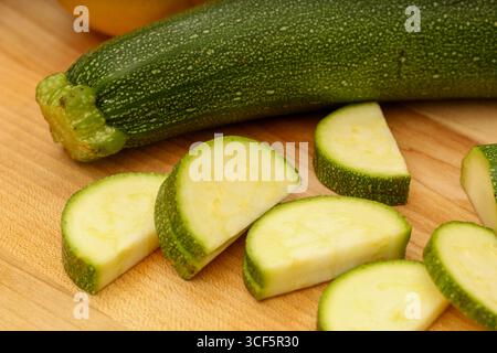 Garlic, Lemon, and Zucchini on Wooden Cutting Board Stock Photo