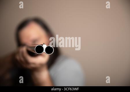 A man is holding a shotgun and looking at the camera Stock Photo