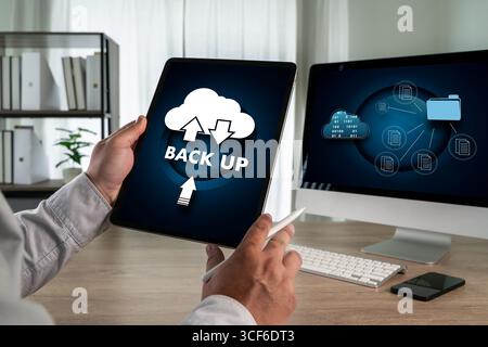 Cloud technology backup concept with a person using a tablet showing cloud storage icons and data transfer, representing secure online file backup, da Stock Photo
