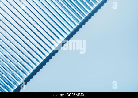 Striped ribbed diagonal glass on blue background Stock Photo