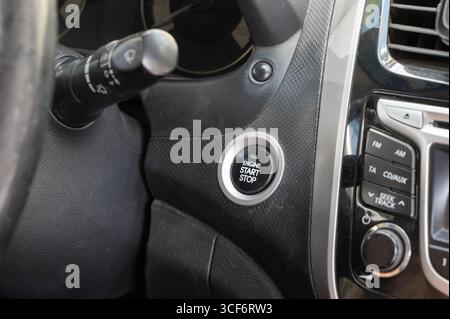 A closeup view of a cars ignition startstop button illustrates the advanced modern automotive technology in use Stock Photo